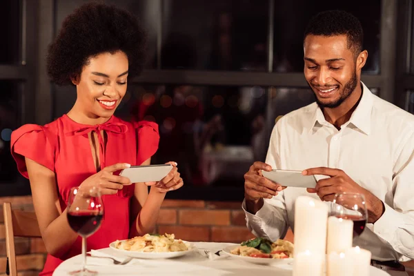 Małżonkowie robiący zdjęcia jedzenia ignorujący się nawzajem w czasie randki — Zdjęcie stockowe