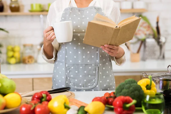 Frau liest Kochbuch und trinkt Kaffee, Ernte — Stockfoto