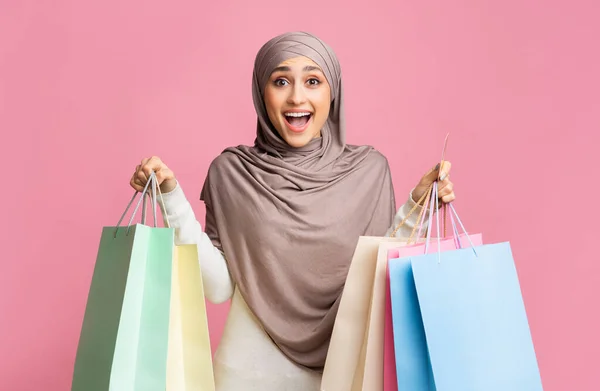 Heyecanlı Müslüman kız bir sürü alışveriş çantası ve kredi kartı tutuyor. — Stok fotoğraf
