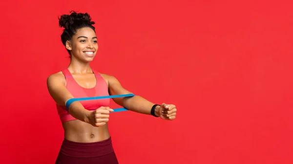 Happy afro girl doing stretching work out with elastic bands — Stock Photo, Image
