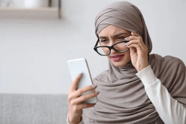 Donna musulmana con problemi alla vista guardando lo schermo dello smartphone — Foto Stock