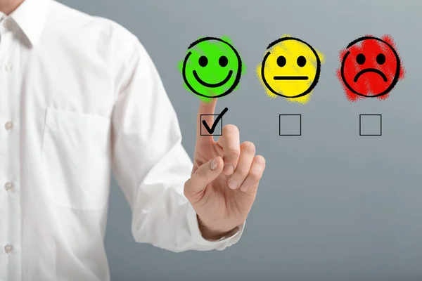 Mano tictac el icono de la cara sonriente feliz sobre fondo gris —  Fotos de Stock