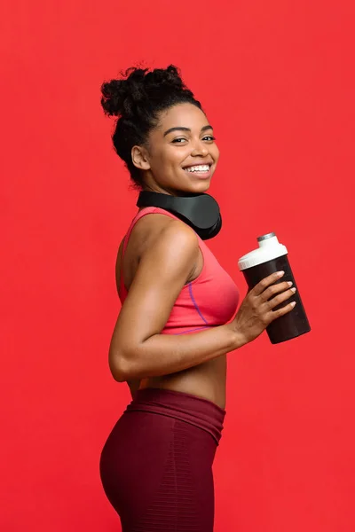 Retrato de menina atlética alegre em sportswear segurando shaker — Fotografia de Stock