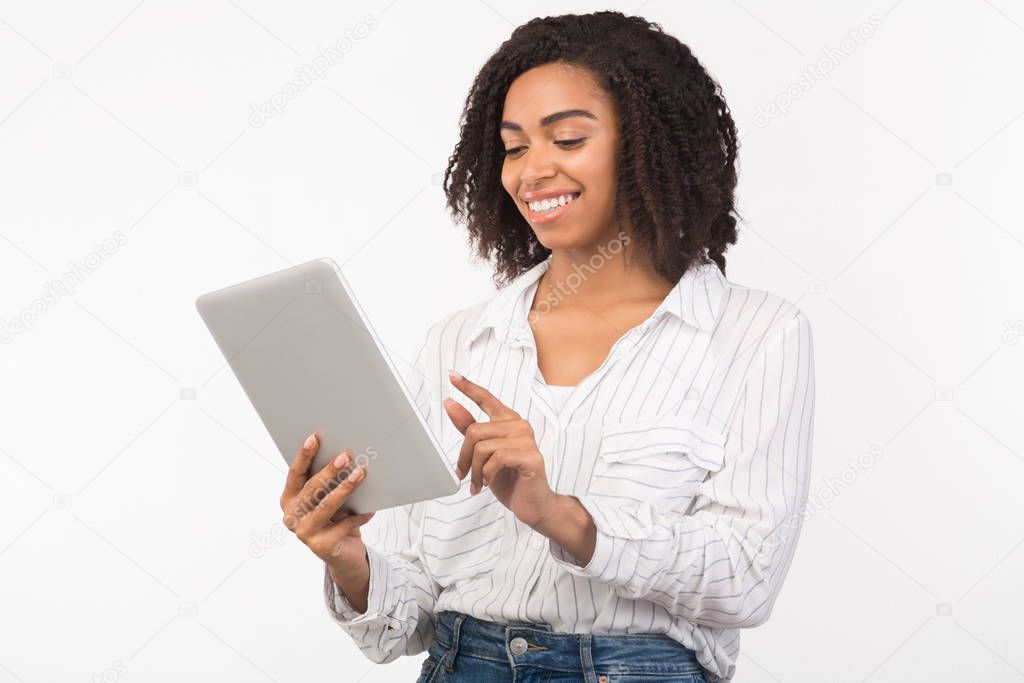 Smiling afro woman reading email on digital tablet