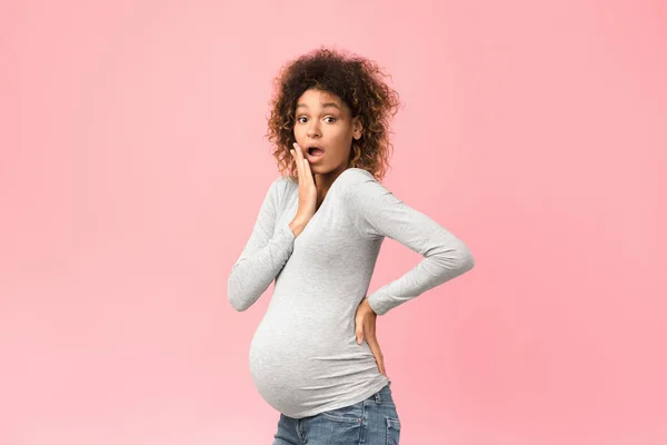 Surpreendido mulher grávida preta fechando boca, fundo rosa — Fotografia de Stock