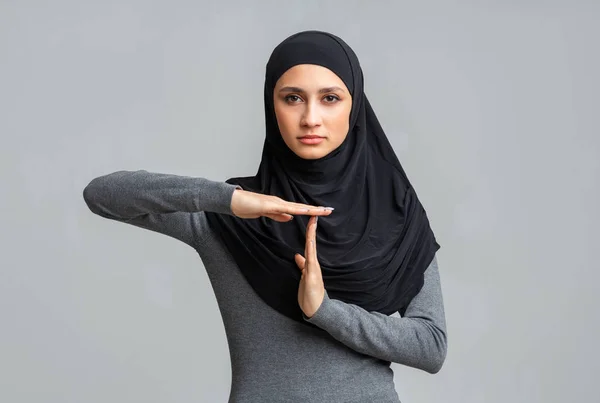 Серйозна ісламська дівчина демонструє жест часу, демонструючи знак перерви у часі — стокове фото