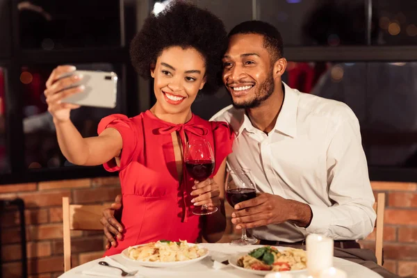Amoroso casal afro fazendo selfie durante data romântica no restaurante — Fotografia de Stock