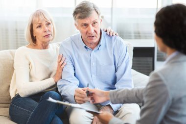 Senior couple talking to financial advisor at home clipart