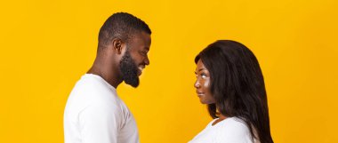 Siyah kız ve erkek birbirlerine bakıyorlar.