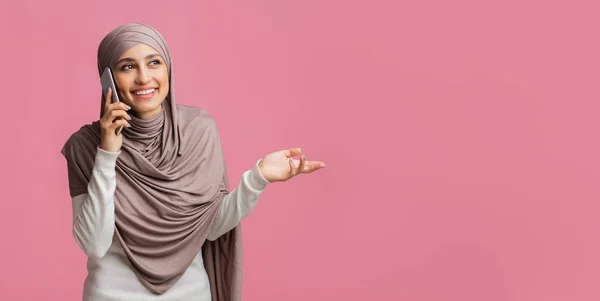 Smiling islamic girl in headscarf talking on cellphone, having plesant call — Stok Foto