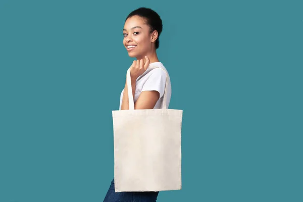 Mujer afroamericana con posada blanca Eco Bag, fondo turquesa —  Fotos de Stock