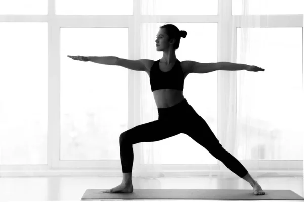 Silhouette of woman making warrior yoga pose — Stock Photo, Image