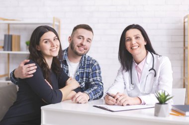 Neşeli hastalar yıllık sağlık kontrolünde doktorla oturuyorlar.