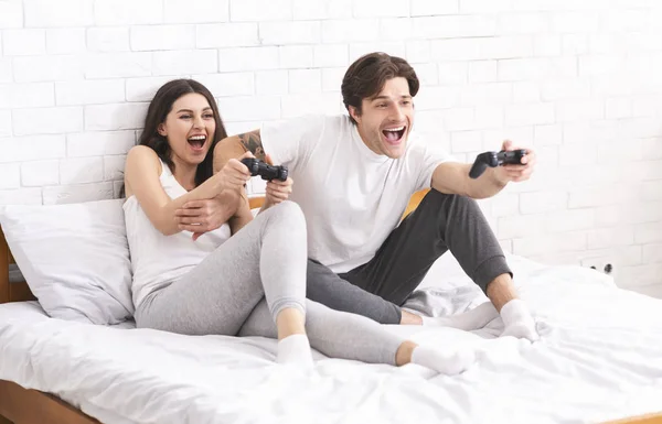 Emotional spouses enjoying video games in bedroom — 스톡 사진