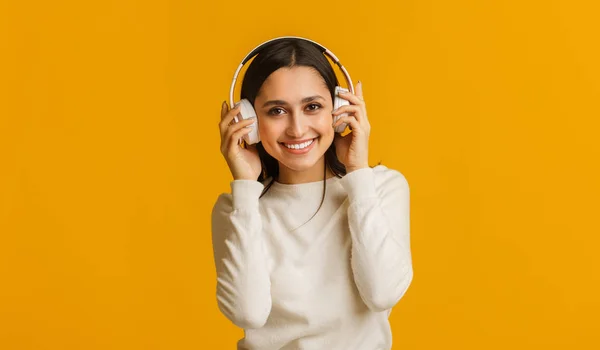 Portrait de fille heureuse écoutant sa musique préférée dans les écouteurs sans fil — Photo