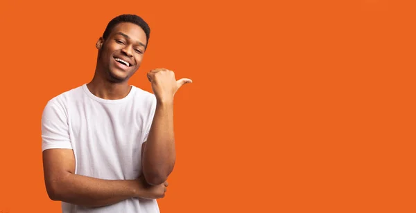 Joven afro chico apuntando al espacio de copia con el pulgar hacia arriba — Foto de Stock