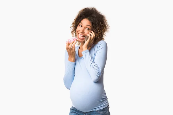 Negro esperando mujer comiendo donut y hablando por teléfono — Foto de Stock