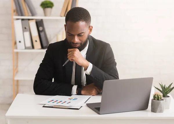 Homme d'affaires sérieux travaillant sur le rapport financier dans son bureau — Photo