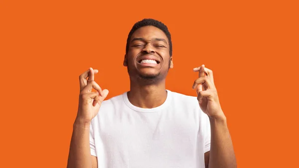 Hopeful african american guy crossing his fingers — Stock Photo, Image