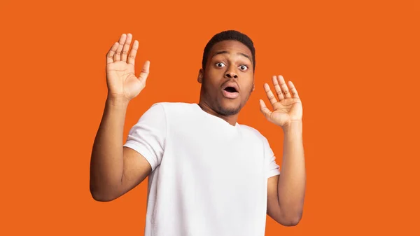 Terrified afro guy over orange studio background — 스톡 사진