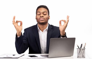 Siyahi adam ofiste meditasyon yapıyor stresle boğuşuyor.