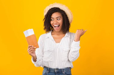 Bilet ve pasaport taşıyan siyah bir kadın.