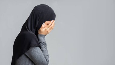 Ağlayan Müslüman kadının portresi elleriyle yüzünü örtüyor.