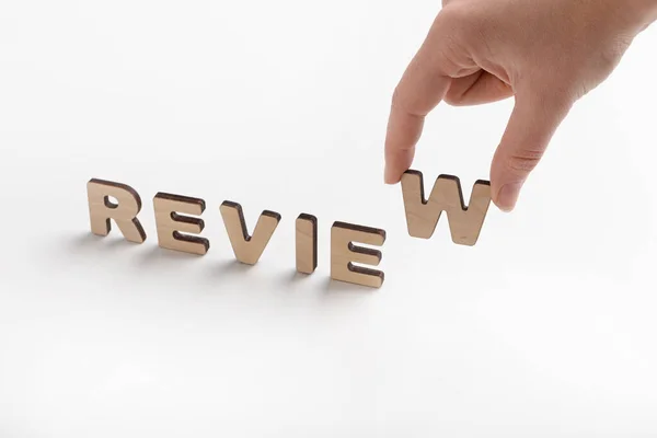 Woman put review word of wooden letters on white — 스톡 사진