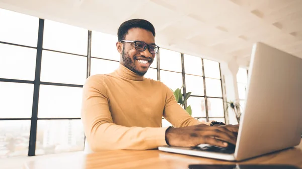 Sorrindo afro-americano cara usando computador pessoal — Fotografia de Stock