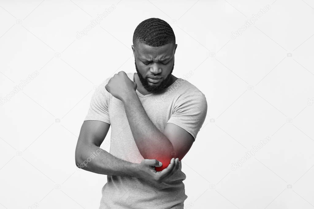 Monochrome photo of afro man holding his elbow