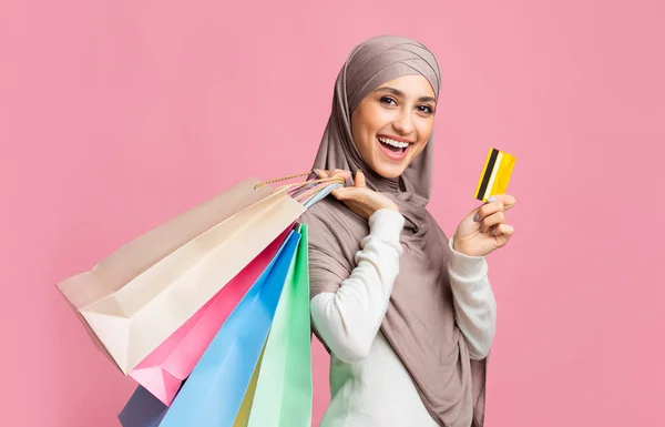 Happy islamic girl dengan tas belanja berwarna-warni dan kartu kredit — Stok Foto