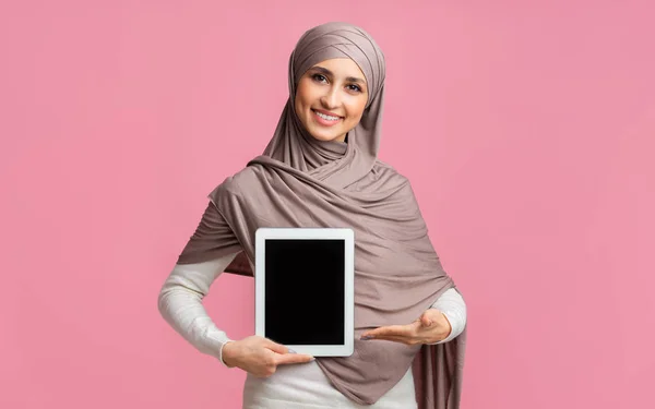 Muslim gadis dalam jilbab menunjuk pada tablet digital dengan layar hitam — Stok Foto