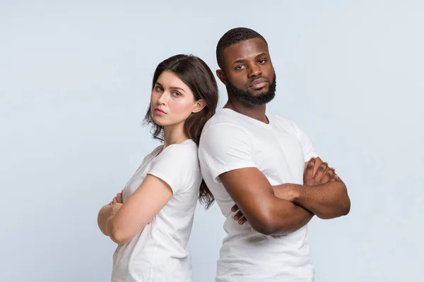 Unhappy multiracial couple standing back to back after conflict — ストック写真