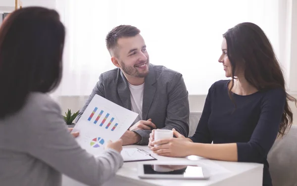 Gelukkige echtgenoten in vergadering met financieel adviseur bij bank — Stockfoto