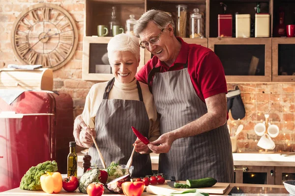 Kıdemli adam ve kadın mutfakta sağlıklı salata hazırlıyorlar. — Stok fotoğraf