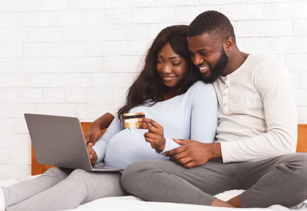 Smiling expecting woman shopping online with husband, using laptop — 图库照片