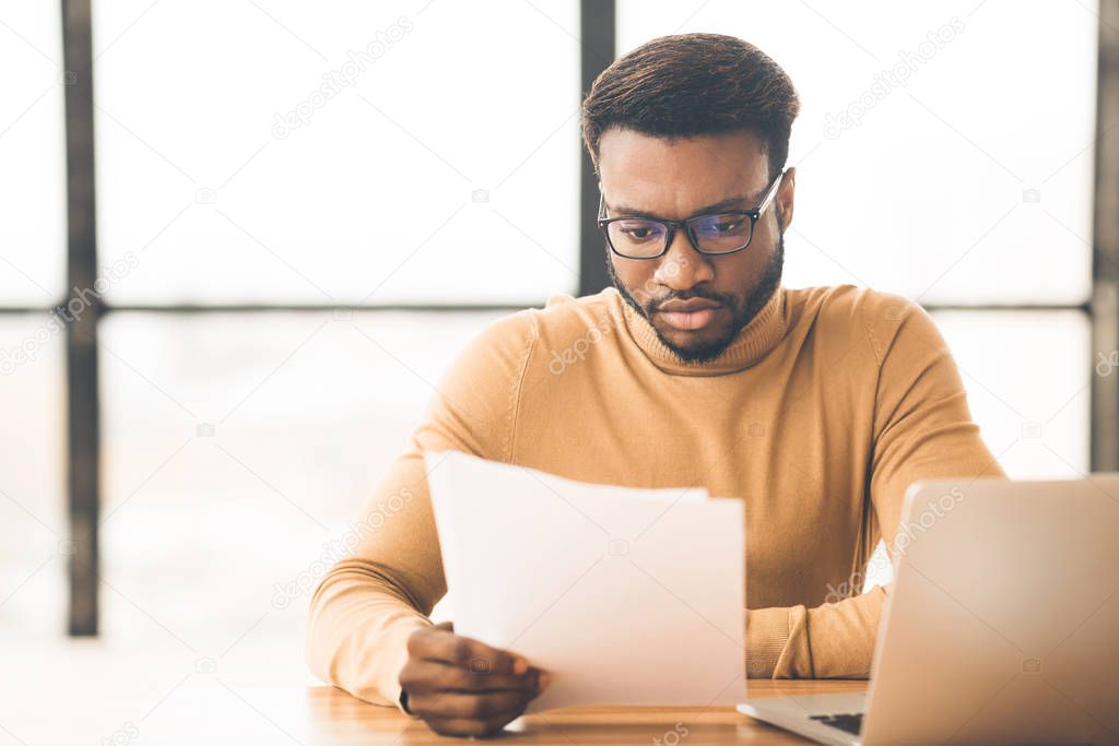 African american manager checking reports in modern office