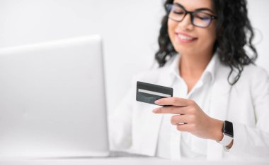 Ofiste kredi kartı kullanan gülümseyen İspanyol iş kadını.