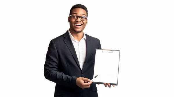 Sonriente chico negro mostrando portapapeles en blanco en la oficina — Foto de Stock