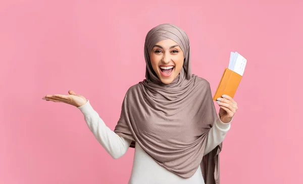 Muslim woman holding passport with boarding tickets and pointing aside — Stock Photo, Image