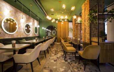 Modern tarzda bir restoran, yeşil duvarlı açık renk iç mekan.