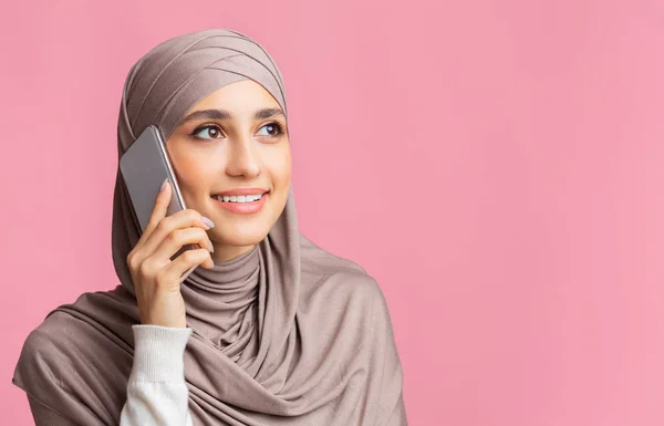 Başörtülü güzel İslamcı kız cep telefonuyla konuşuyor ve başka tarafa bakıyor. — Stok fotoğraf