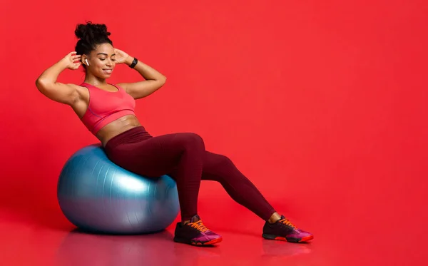 Молодая спортивная чернокожая девушка тренируется с фитнес-мячом — стоковое фото