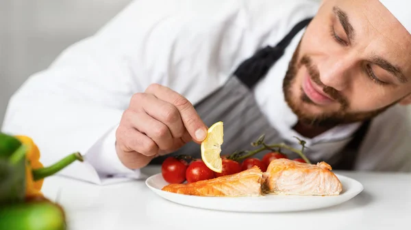 Piatto di pesce arrosto di placcatura dello chef che decora il cibo nella cucina del ristorante — Foto Stock