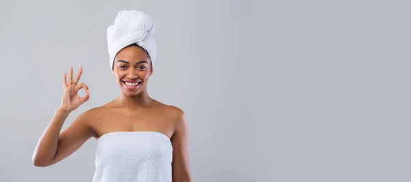 Mulher satisfeita em toalhas mostrando gesto ok e sorrindo — Fotografia de Stock