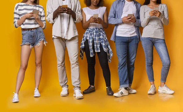 Grupo de amigos adolescentes de raza mixta usando teléfonos inteligentes, recortados — Foto de Stock