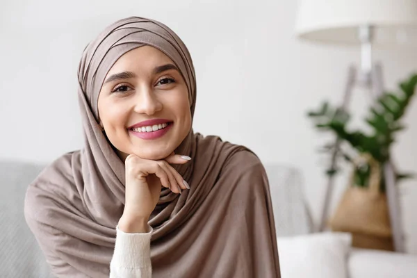 Portrét usměvavé muslimské dívky v hidžábu odpočívající hlavu na ruce — Stock fotografie