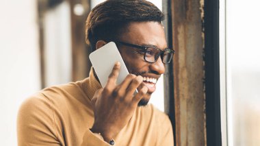 Ofiste cep telefonuyla konuşan Afrikalı adam.