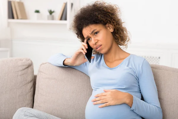 Сумна вагітна жінка говорить по телефону зі своїм лікарем — стокове фото