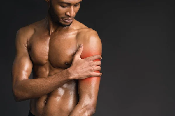 Hombre afro guapo sin camisa que sufre de dolor en el brazo — Foto de Stock